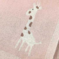 Pink knitted giraffe baby blanket for infants featuring a white and brown giraffe design