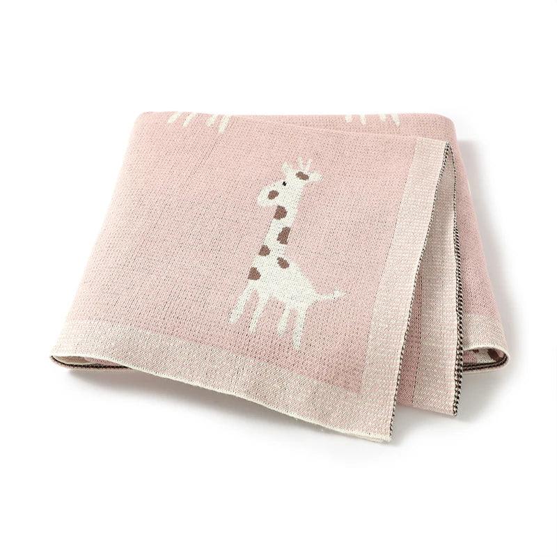 pink knitted giraffe baby blanket for babies with cute white and brown giraffe design