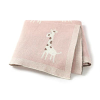pink knitted giraffe baby blanket for babies with cute white and brown giraffe design