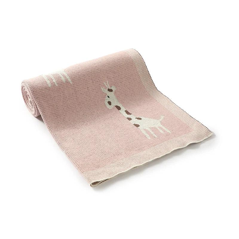 Pink knitted giraffe baby blanket with white and brown giraffe design for infants