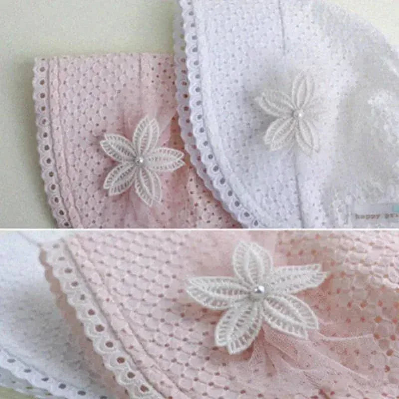 White and pink lace baby bonnet with floral applique for newborns displayed flat