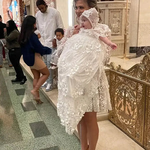 white lace baptism gown for babies with floral detailing and matching bonnet held by woman