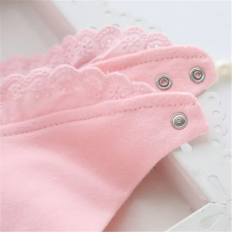 Close-up of pink lace bib for babies with snap button closures for easy fastening