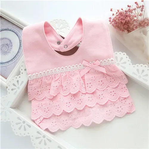 pink lace bib for babies with scalloped edges and bow detail for infant feeding