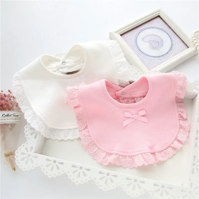 White and pink lace bib for babies with frilled edges and bow detail for infant feeding
