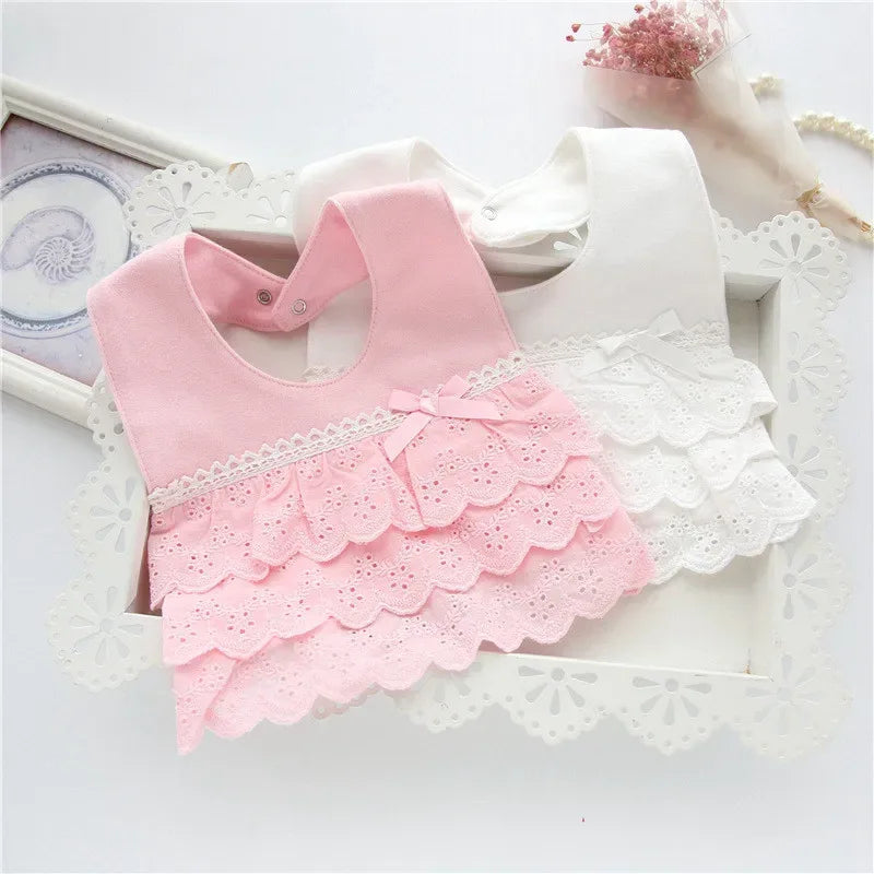 pink and white lace bib for babies with scalloped edges and bow detail for infant girls
