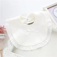 white lace bib for babies with scalloped edges and small bow for newborns and infants