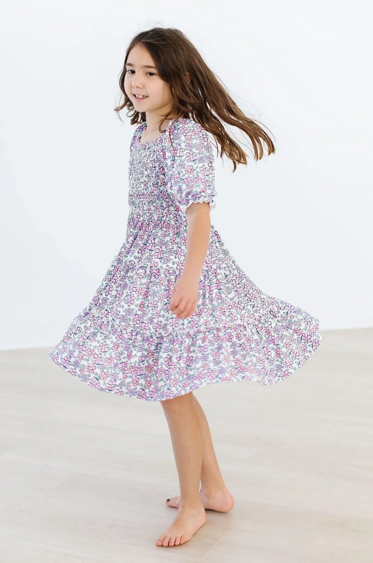 Girls lavender floral smocked dress for girls with ruffle sleeves and flowing skirt