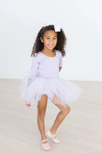 Lavender tutu leotard for toddlers with sleeves worn by young girl with white bow