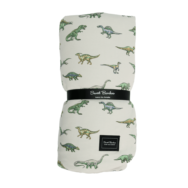 Folded blanket with dinosaur pattern and 'Sweet Bamboo' branding on a green background