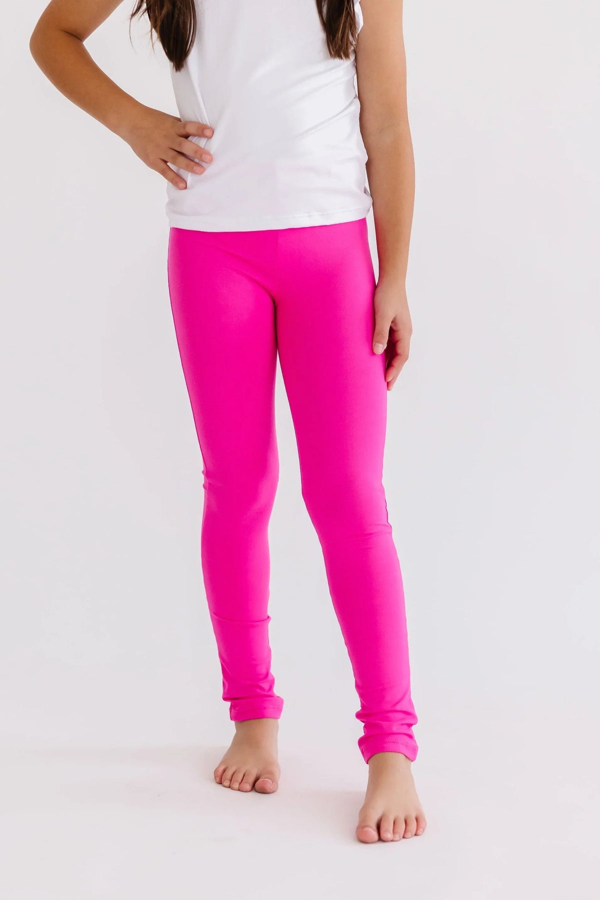 Child wearing bright pink Mila & Rose leggings standing barefoot with one hand on hip