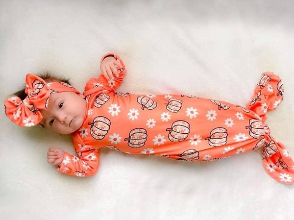 Orange leopard pumpkin baby gown made of soft fabric with matching headband on infant