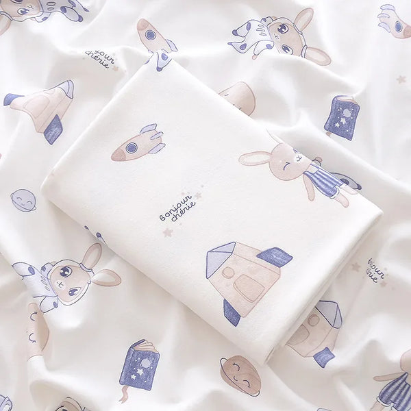 Lightweight cotton baby swaddle blanket in white with beige and blue space and bunny print for newborns