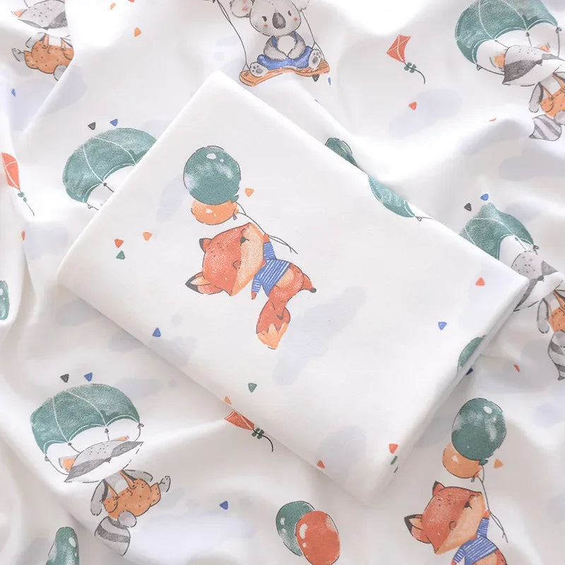 White lightweight cotton baby swaddle blanket with animal and balloon print for newborns