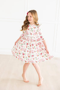 young girl wearing white floral ruffle twirl dress 3/4 sleeves spinning indoors