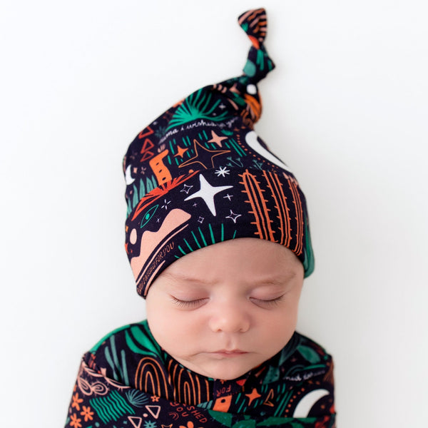 Sleeping baby wearing Desert Cactus Midnight SoftKnot Cap, a cozy bamboo newborn hat with a knot.