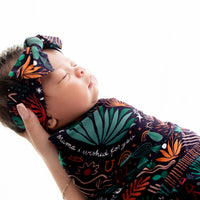 Baby snug in The Forever Swaddle Blanket Desert Cactus Midnight, 48x48 bamboo blend swaddle.