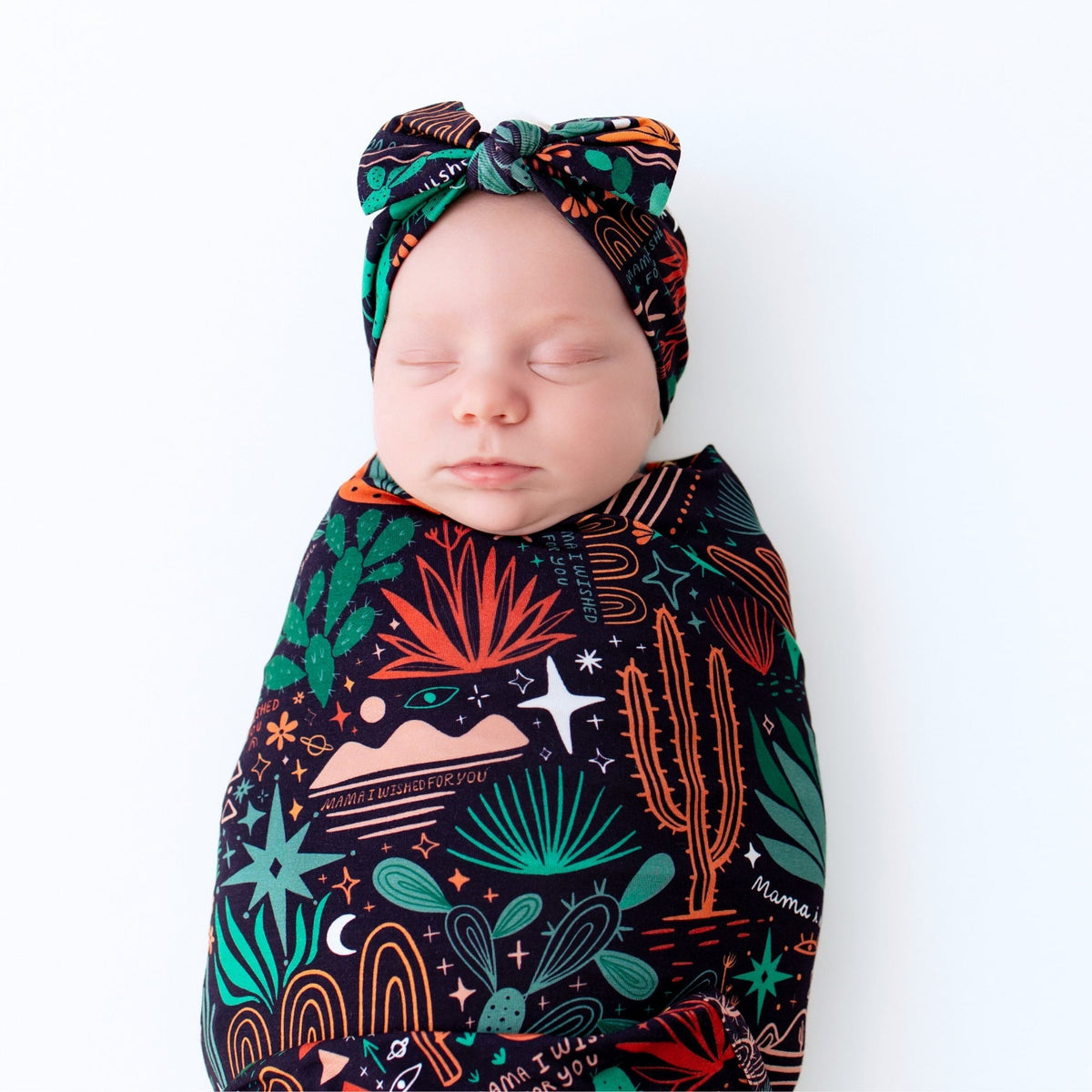 Sleeping baby wrapped in Desert Cactus Midnight Forever Swaddle Blanket.