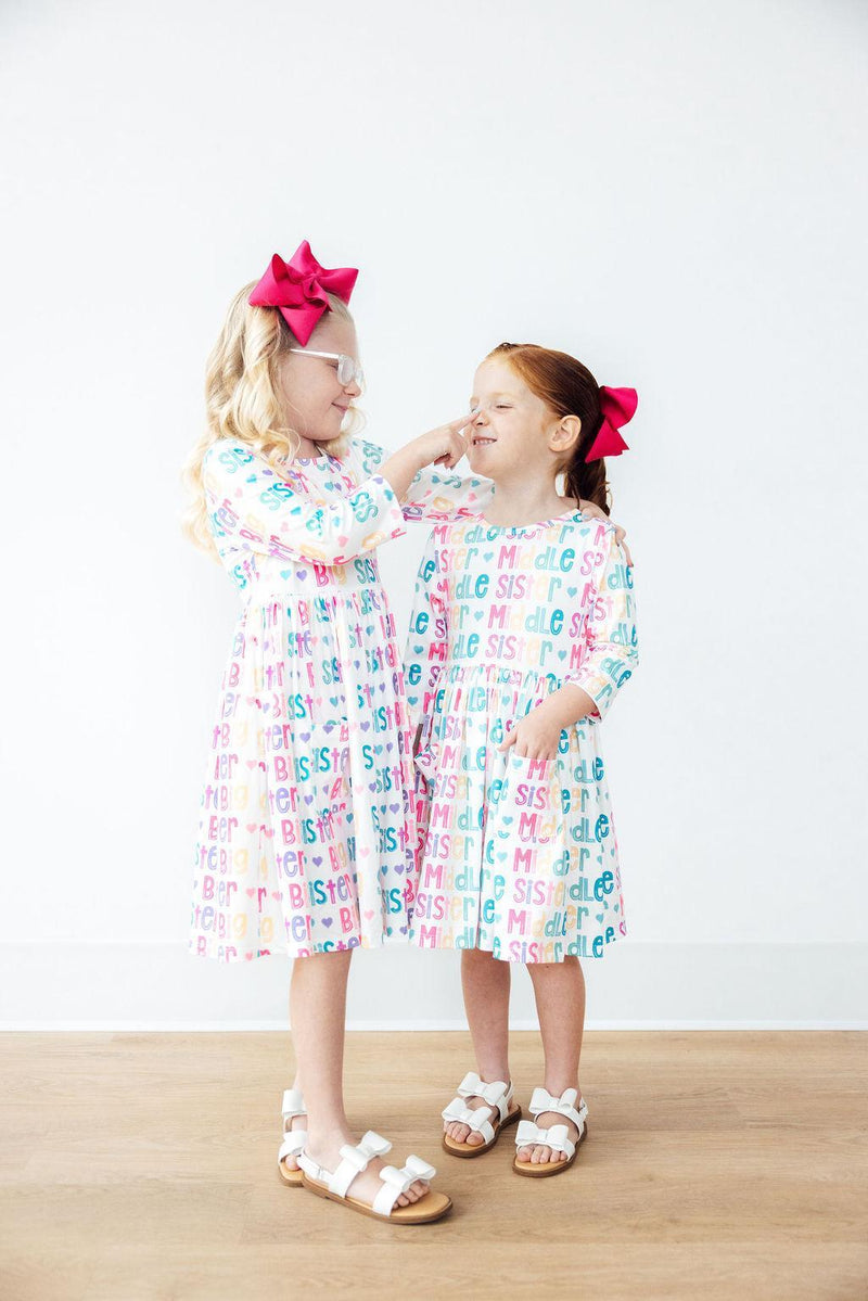The Big Sister 3/4 Sleeve Pocket Twirl Dress for Girls hung elegantly, highlighting its full-circle skirt which makes it the perfect twirl dress for girls, suitable for school or special occasions.