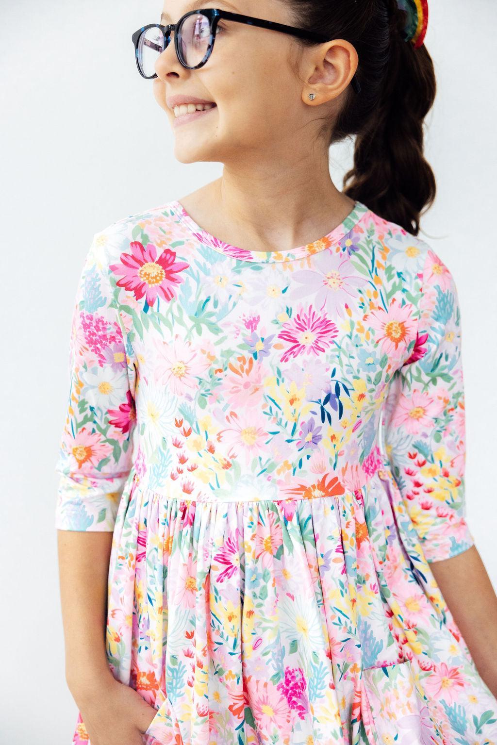 Field of Flowers 3/4 Sleeve Pocket Twirl Dress for Girls showcasing vibrant floral patterns and a playful full-circle skirt, perfect for little princesses twirling through their adventures.
