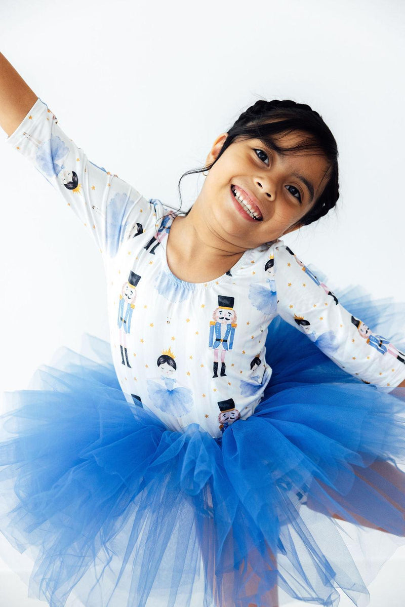 Joyful child in the Waltz of the Snowflakes 3/4 Tutu Leotard from Mila & Rose®, twirling in a blue tutu with a happy expression.