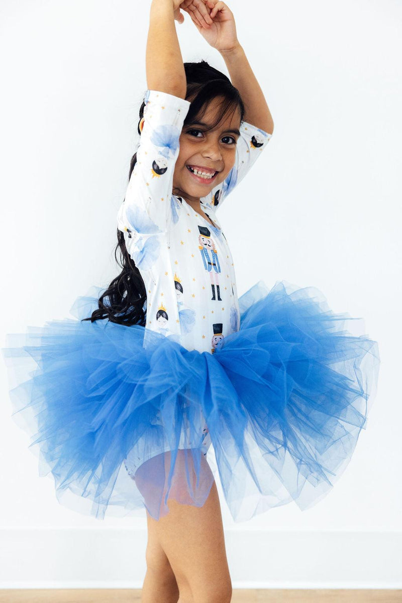 Delighted girl in profile wearing the Waltz of the Snowflakes 3/4 Tutu Leotard from Mila & Rose®, with a fluffy blue tutu and a playful dance pose.