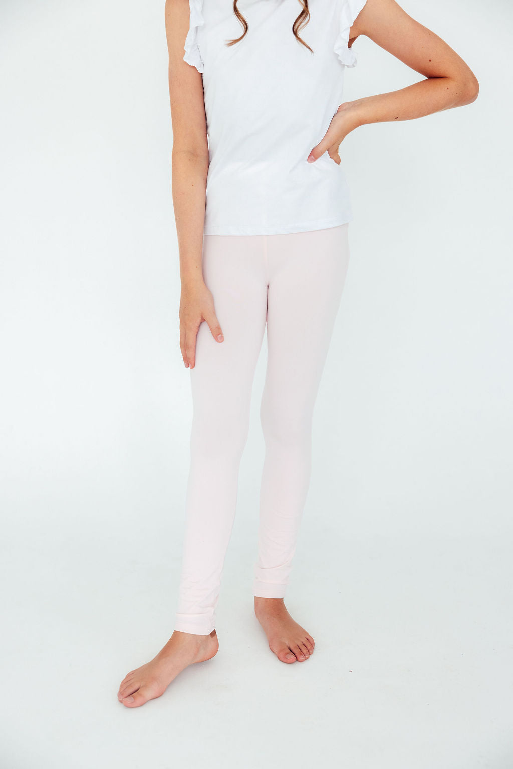 Charming child showcasing Petal Pink Leggings by Mila & Rose, perfectly paired with a casual white top, ready to twirl in style!
