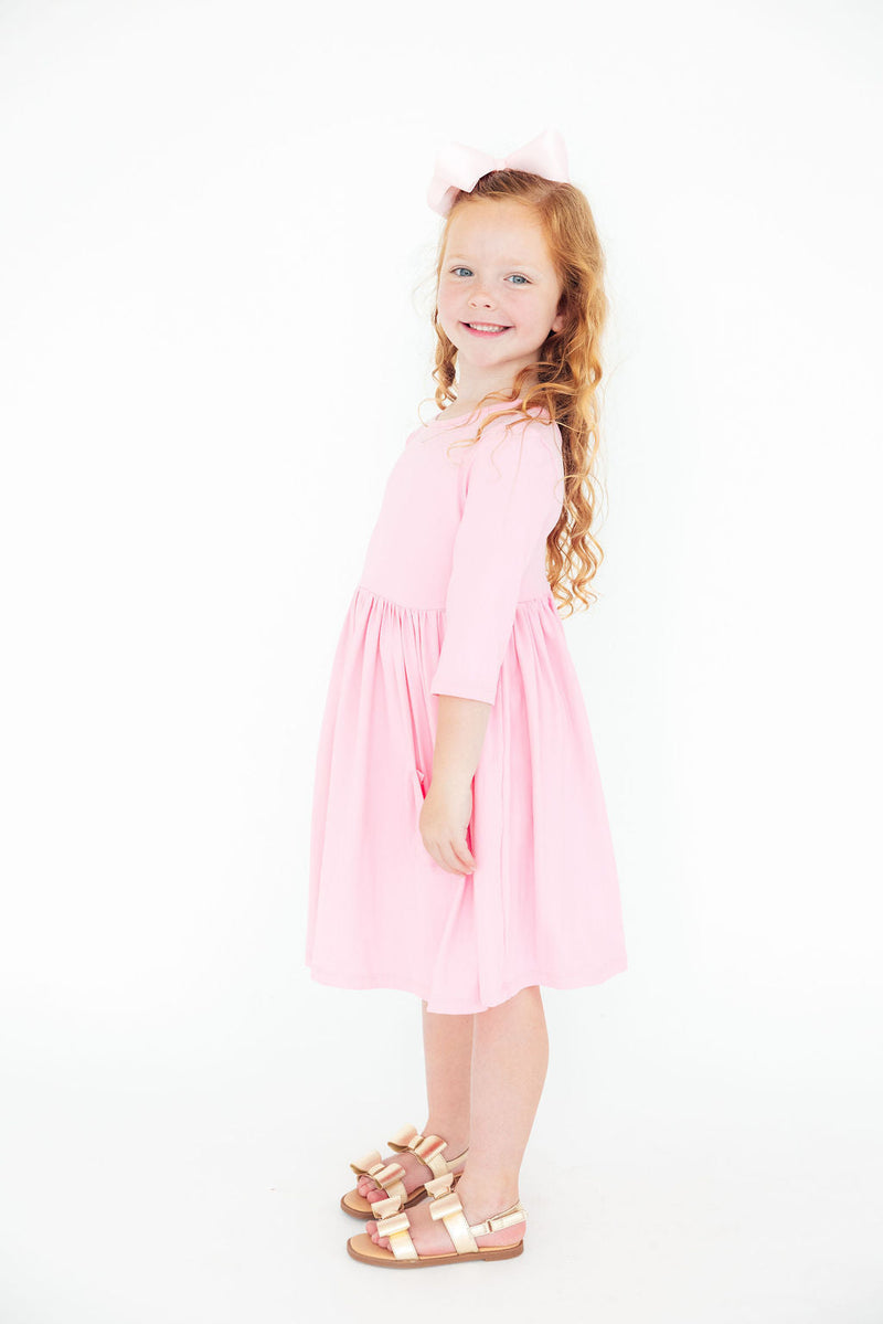 Close-up of the soft fabric of the Bubblegum Pink 3/4 Sleeve Pocket Twirl Dress for Girls, highlighting its comfort and stretch for all-day play.