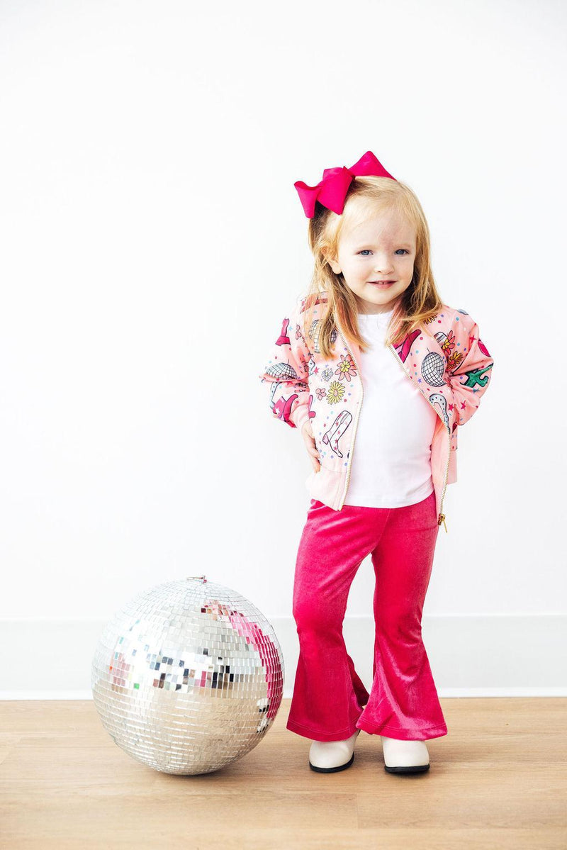 A girl wearing the Boots & Bling Satin Jacket, demonstrating its chic look paired with a playful twirl dress.