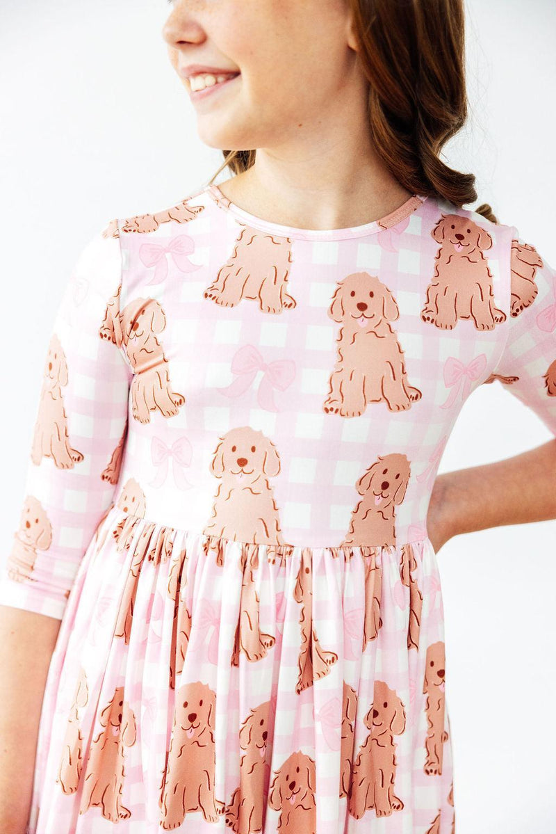 Close-up of a girl smiling in the Goldendoodle 3/4 Sleeve Pocket Twirl Dress for Girls, highlighting the cute dog pattern, perfect for a stylish pocket twirl dress.