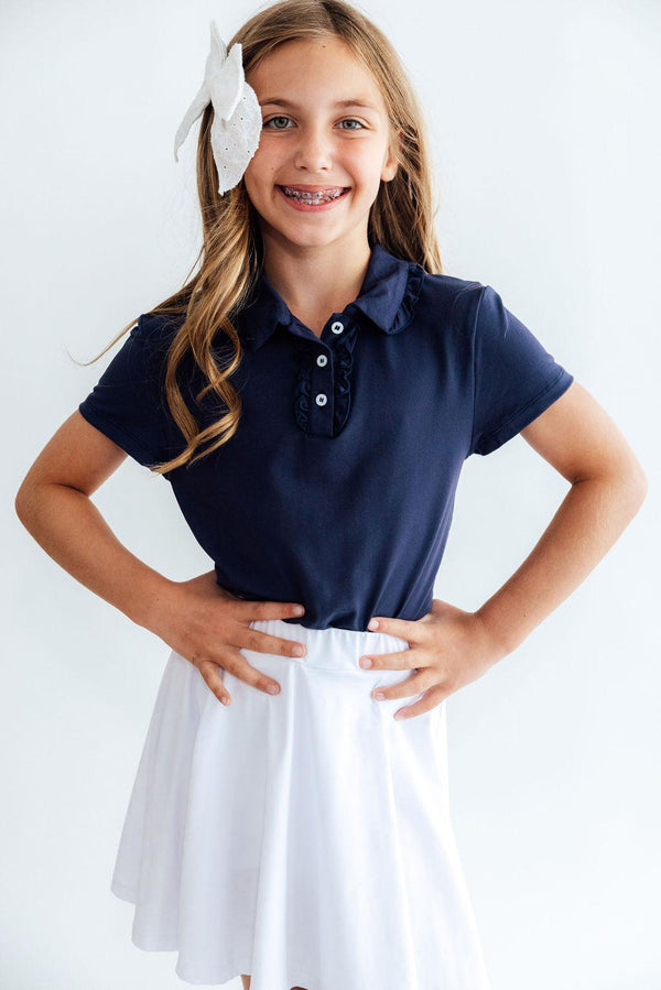 Girls navy short sleeve ruffle polo shirt with classic collar and button placket, paired with a white skirt for polished school style.