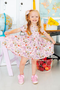 Playground Princess short sleeve pocket twirl dress on a smiling toddler in a bright classroom.