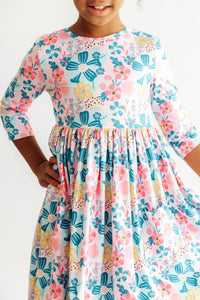 Girl in Floral Garden 3/4 Sleeve Pocket Twirl Dress for Girls with pink and blue floral print and twirl skirt.