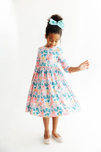 Girl in Floral Garden 3/4 sleeve twirl dress with pastel florals and teal bow.