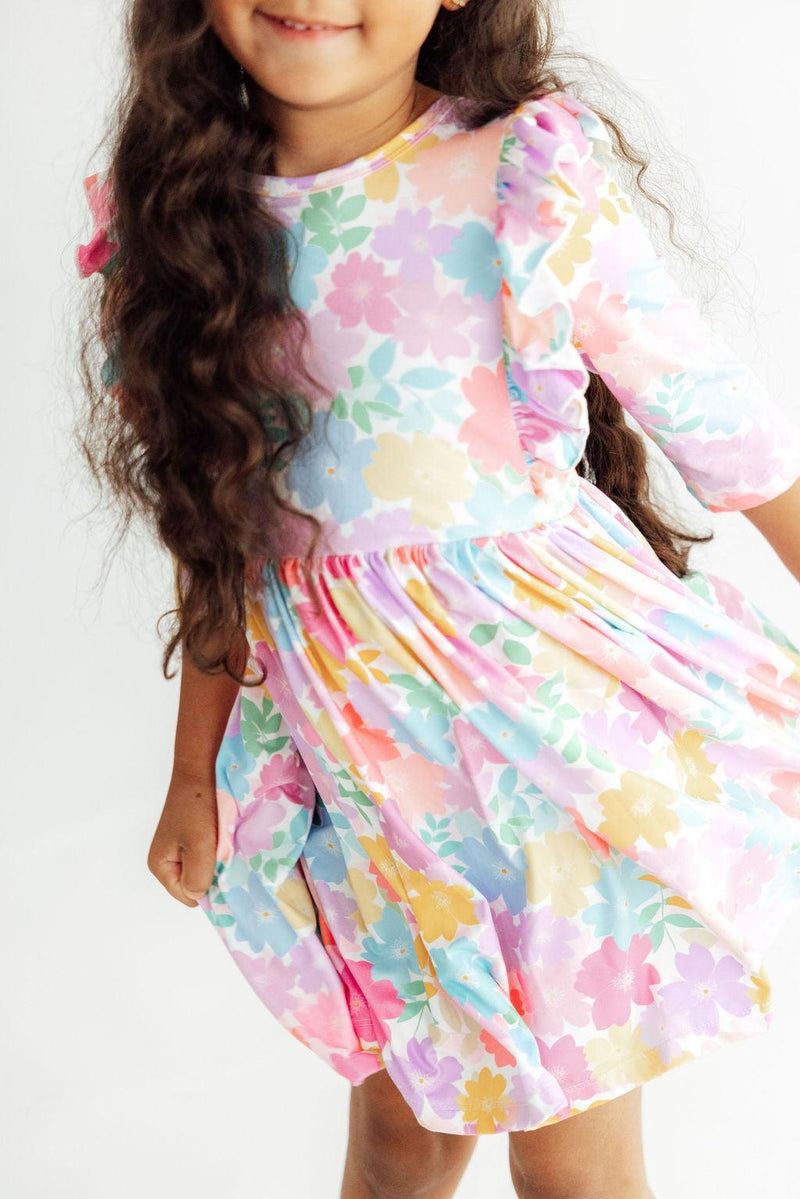 Colorful carnation-print girls' 3/4 sleeve twirl dress with ruffle detail and full-circle skirt.