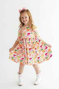 Girl wearing Falling Leaves 3/4 Sleeve Pocket Twirl Dress with colorful leaf print and full twirl skirt.
