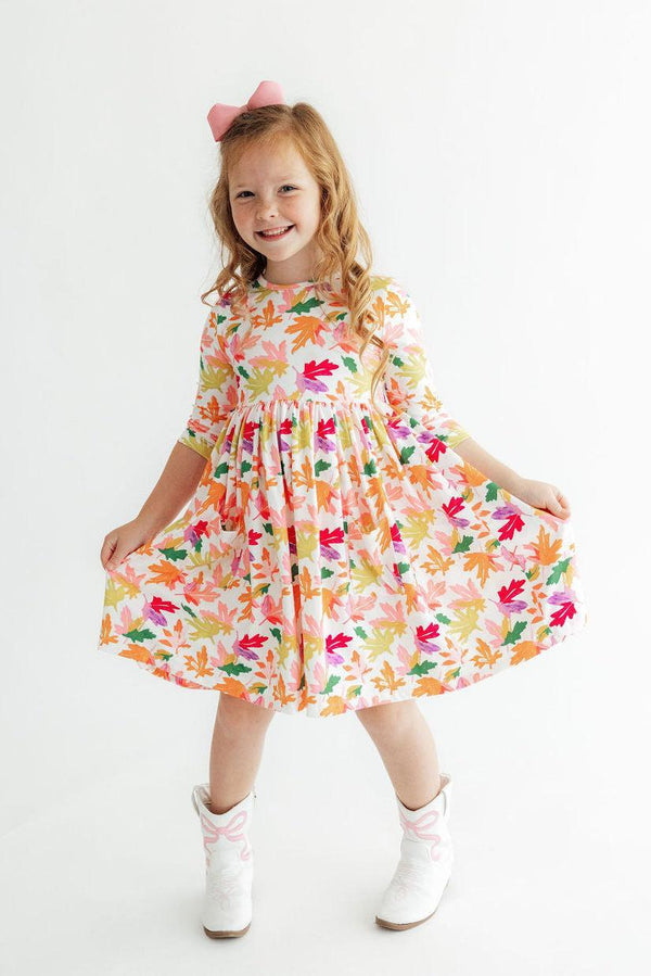 Girl wearing Falling Leaves 3/4 Sleeve Pocket Twirl Dress with colorful leaf print and full twirl skirt.