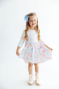 Girl in Here for the Candy 3/4 sleeve twirl dress, pastel candy print, blue bow in hair, twirling happily.