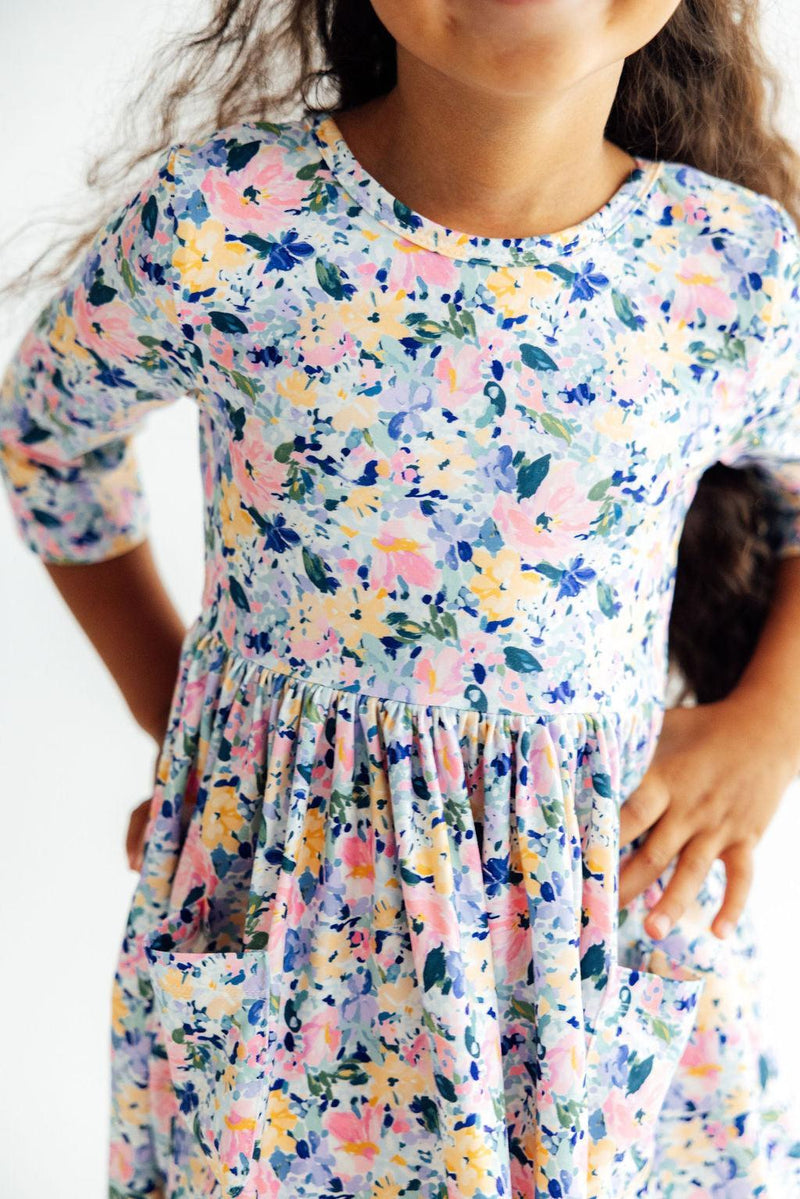 Girl wearing Fall Floral 3/4 Sleeve Pocket Twirl Dress for Girls with pastel print, pockets, full twirl skirt.