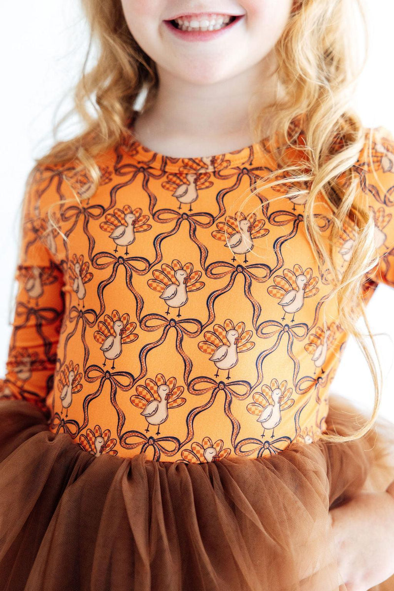 Orange long sleeve tutu dress for girls featuring a turkey and ribbon print with a brown tulle skirt.