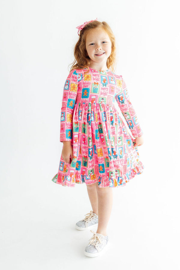 Pink long sleeve ruffle hem twirl dress with festive holiday print, full skirt, and ballet neckline for kids.