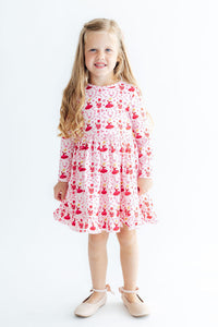 Girl wearing Candy Cane Ballet Long Sleeve Ruffle Hem Twirl Dress in pink with red ballet prints, full twirl skirt.