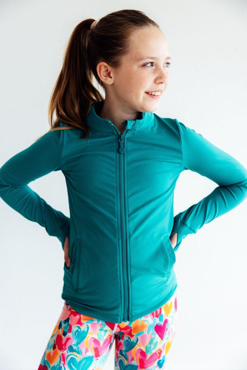 Smiling girl in the Turbo Teal Full-Zip Ruffle Girls Active Jacket, perfect for active lifestyles in girls activewear jackets.