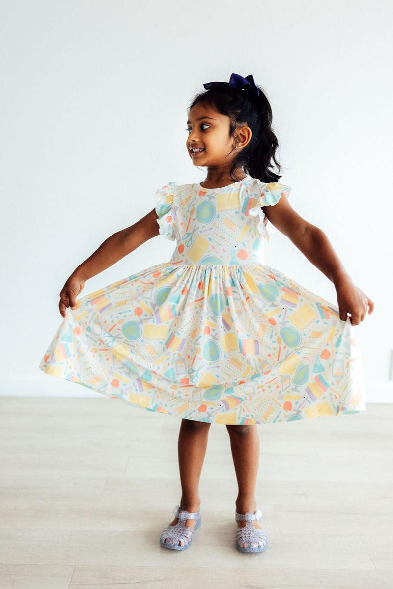 Girls twirling in the Campus Cutie Flutter Sleeve Twirl Dress, showcasing vibrant colors and playful flutter sleeves.