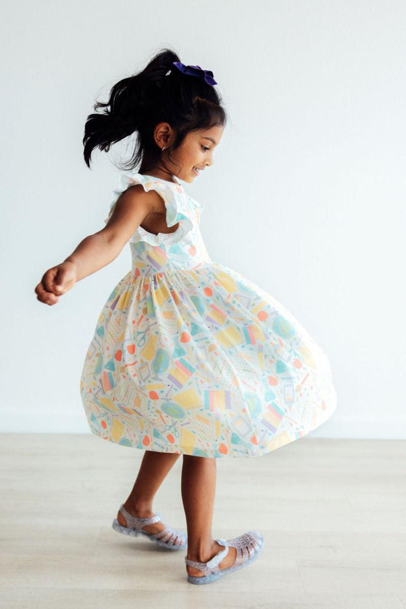 Stylish little girl wearing the Campus Cutie Flutter Sleeve Twirl Dress, perfect for school days and special occasions, with a twirl that brings joy.