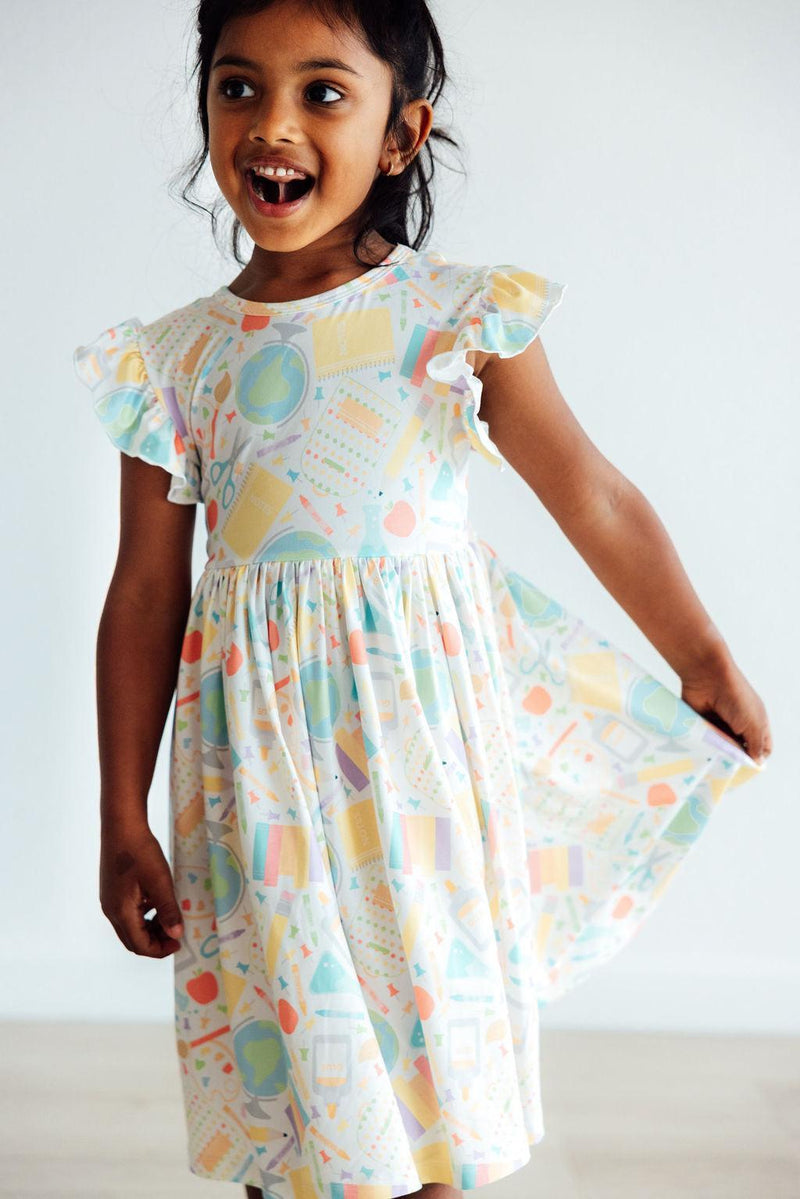 Close-up of the Campus Cutie Flutter Sleeve Twirl Dress for Girls, highlighting the soft fabric and scoop back design for easy dressing.