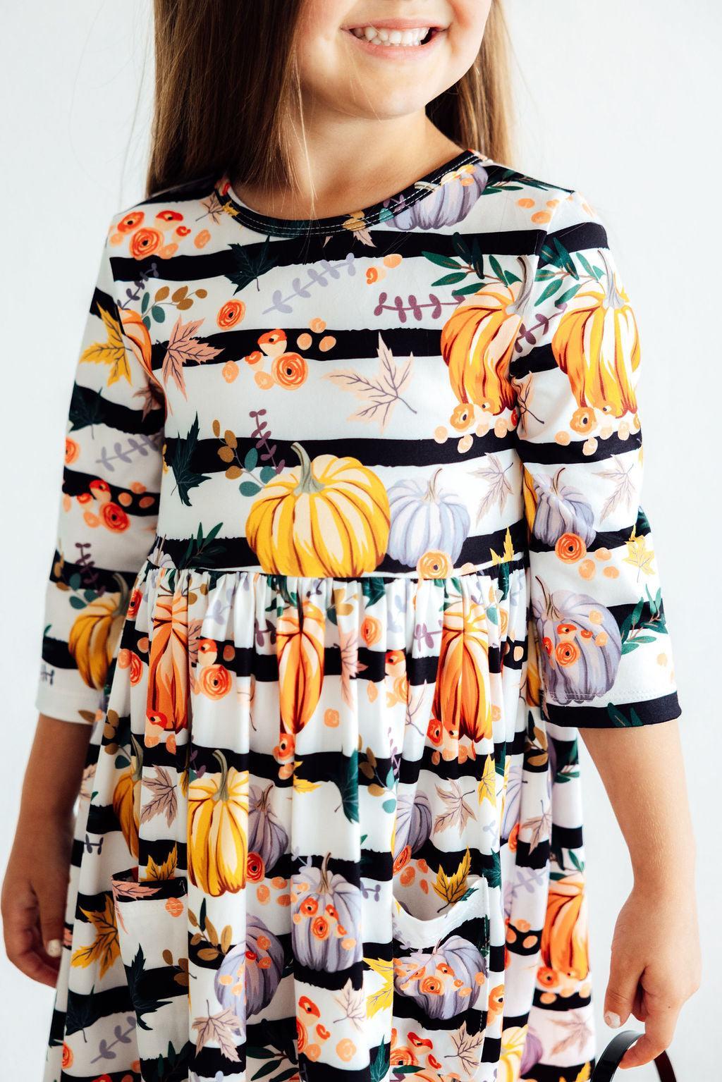 Pumpkins & Peonies 3/4 Sleeve Pocket Twirl Dress showcasing a cheerful girl twirling in vibrant colors, embodying fun and comfort!