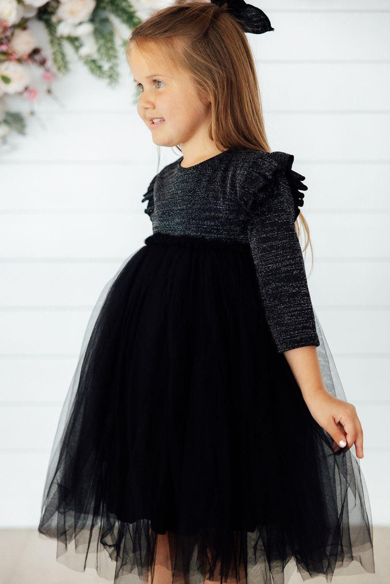 Close-up of the fluffy tutu skirt of the Black Shimmer 3/4 Sleeve Tutu Dress, showcasing the shimmering fabric and voluminous style ideal for little princesses.