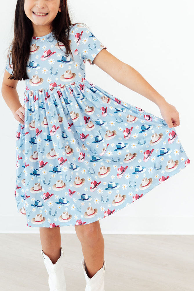 Tip Your Hat Short Sleeve Pocket Twirl Dress For Girls in vibrant colors, featuring a scoop back and short sleeves, perfect for everyday play.