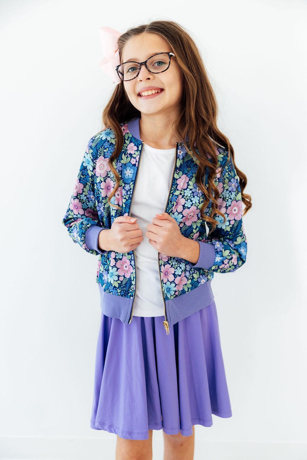 Girl wearing Whimsy Satin Jacket with floral print and lavender cuffs.